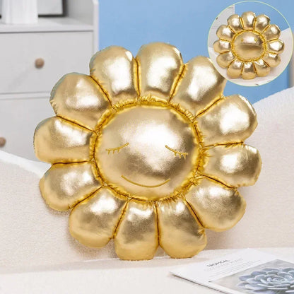 Gold sun-shaped pillow with a face on a white surface
