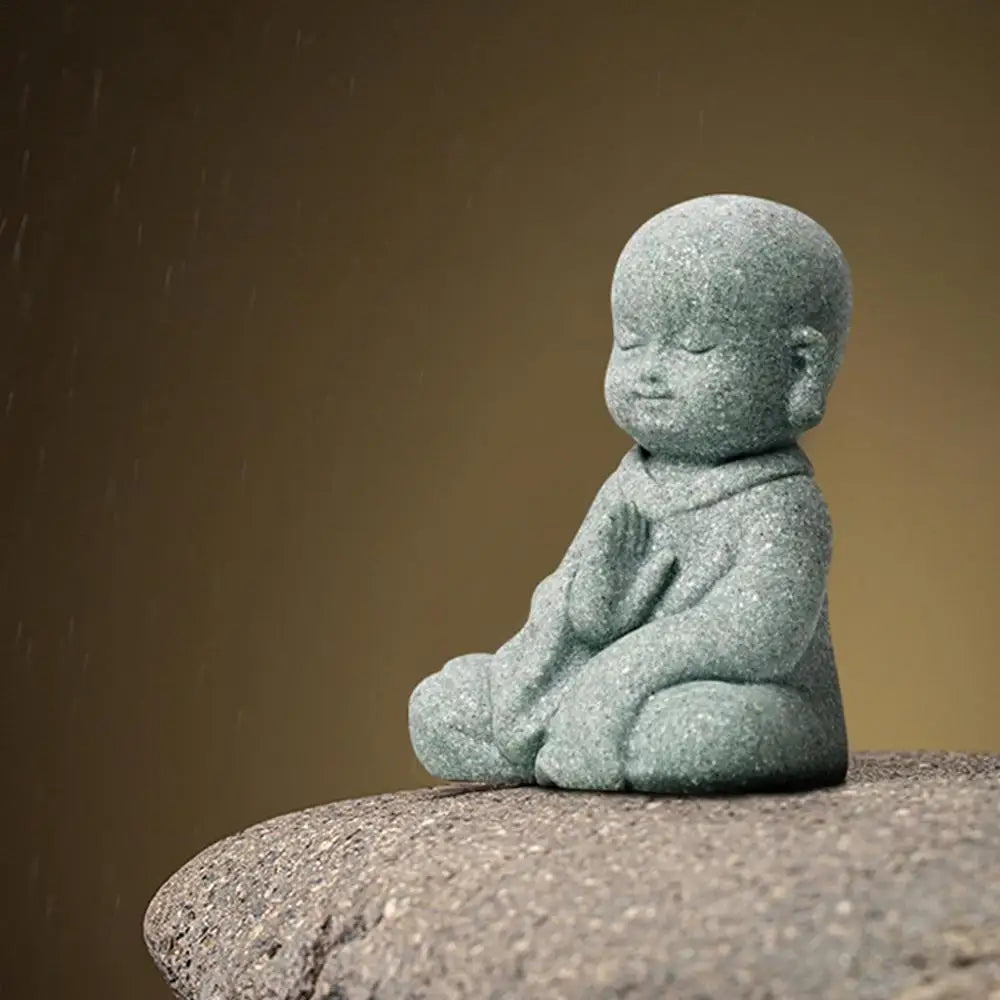 Stone statue of a child sitting on a rock with a brown background