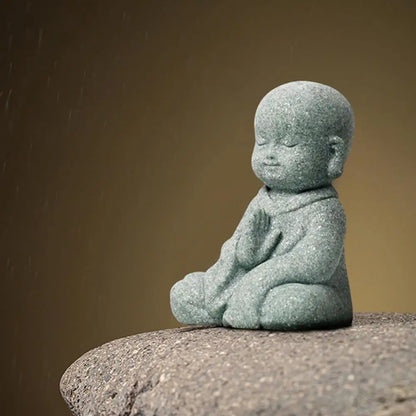 Stone statue of a child sitting on a rock with a brown background