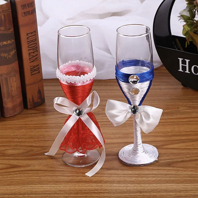 Two decorative wine glasses with ribbons on a wooden surface