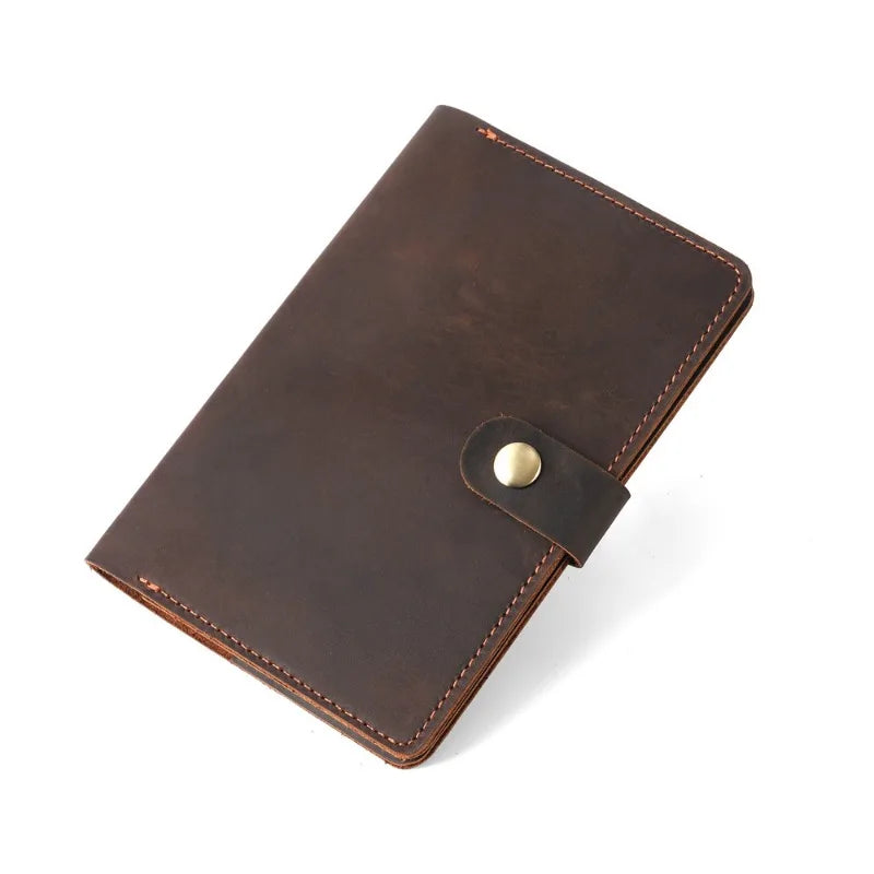 Brown leather notebook with a gold button on a white background