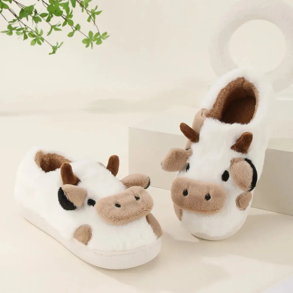 Pair of cow-themed slippers on a light background