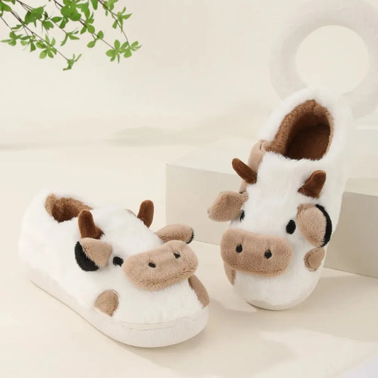 Pair of cow-themed slippers on a light background
