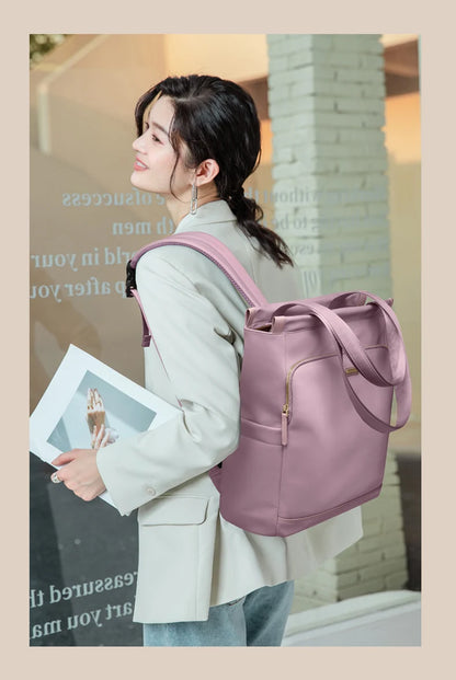Woman carrying a pink backpack with a blurred indoor background