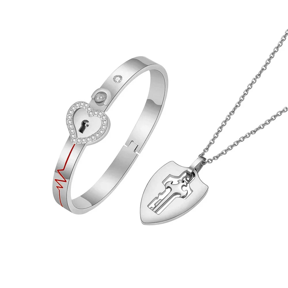 Silver bracelet with heart-shaped lock design and matching necklace on a white background