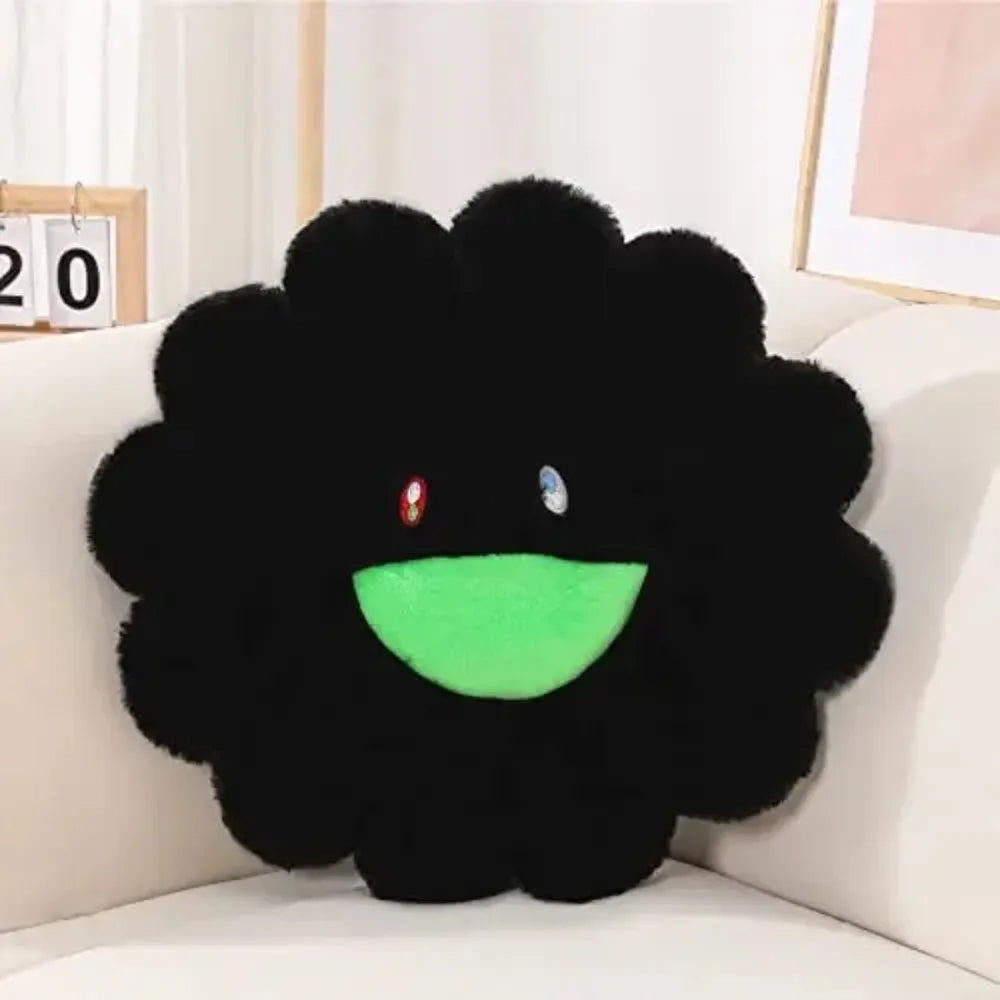 Black plush flower pillow with green center and red and blue eyes on a white couch.