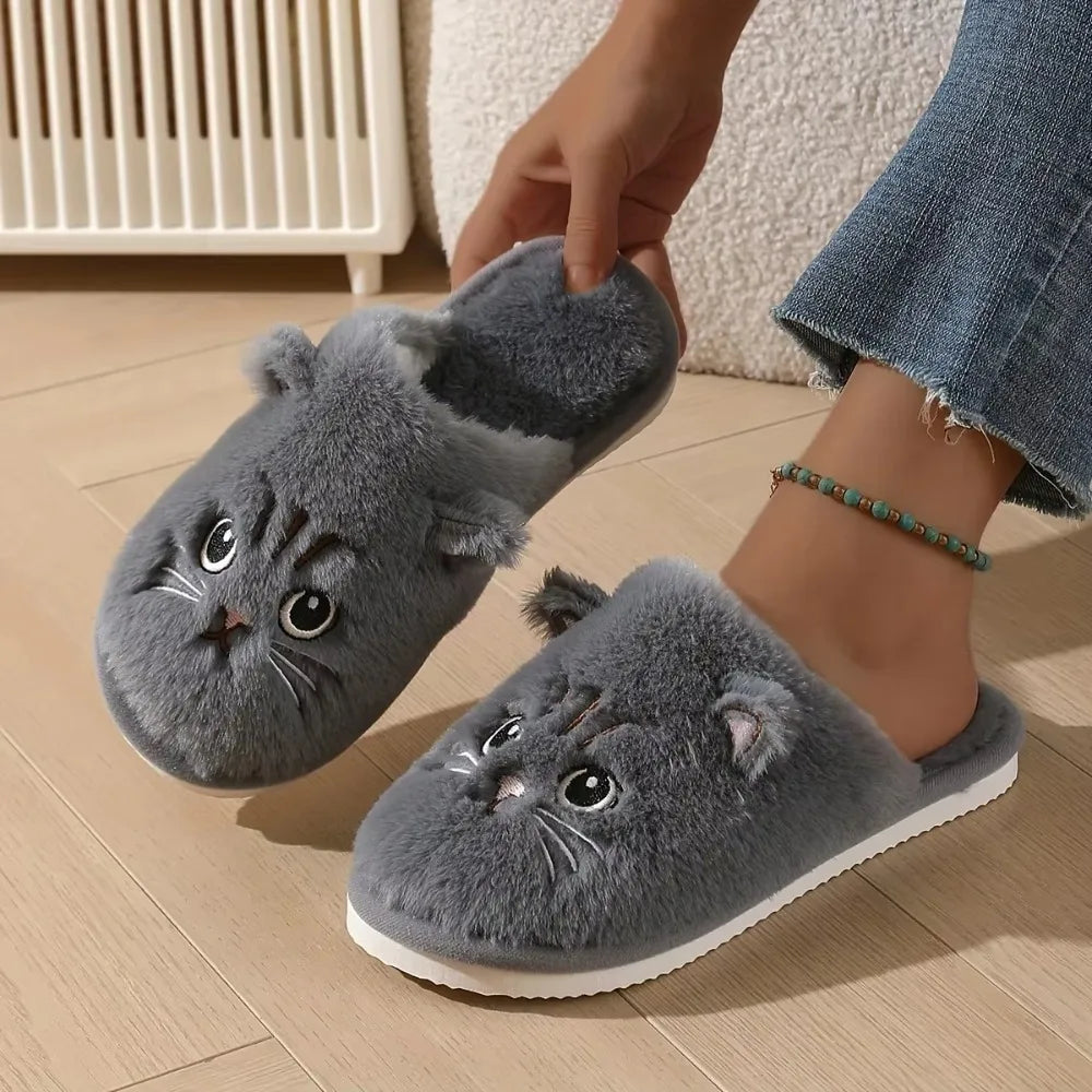 Gray cat-shaped slippers worn on a wooden floor.