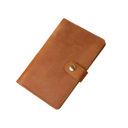 Brown leather notebook with a gold button on a white background