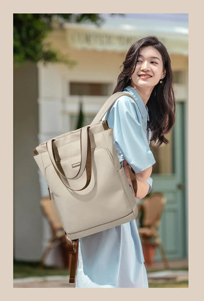 Woman carrying a beige tote bag outdoors