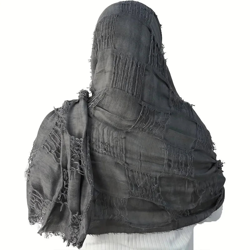 Black fringed scarf draped over a white background