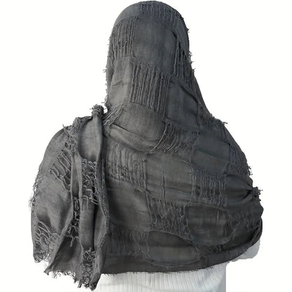 Black fringed scarf draped over a white background