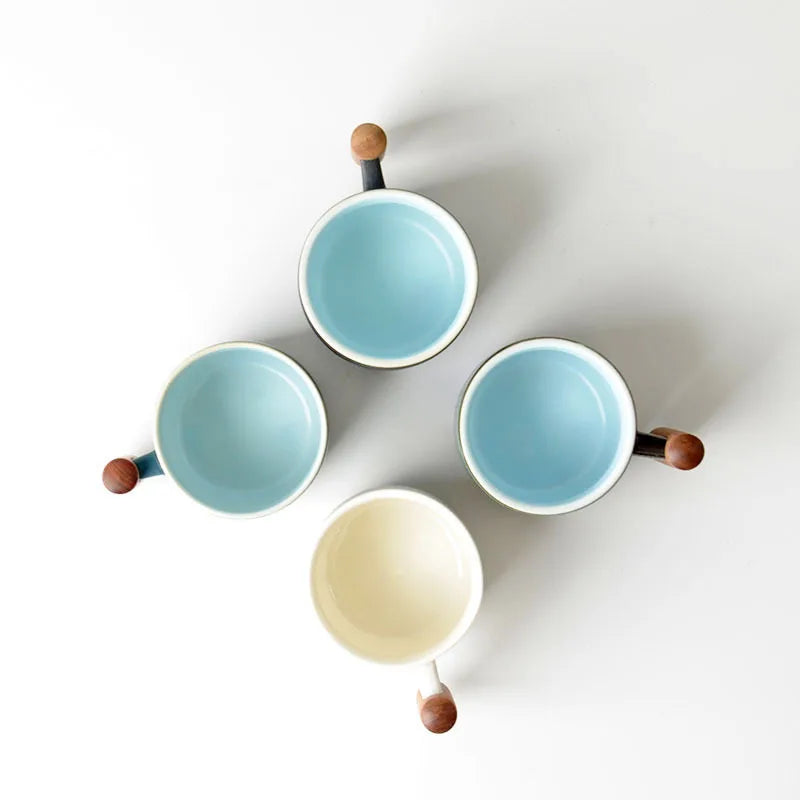 Set of four ceramic bowls with wooden handles on a white background