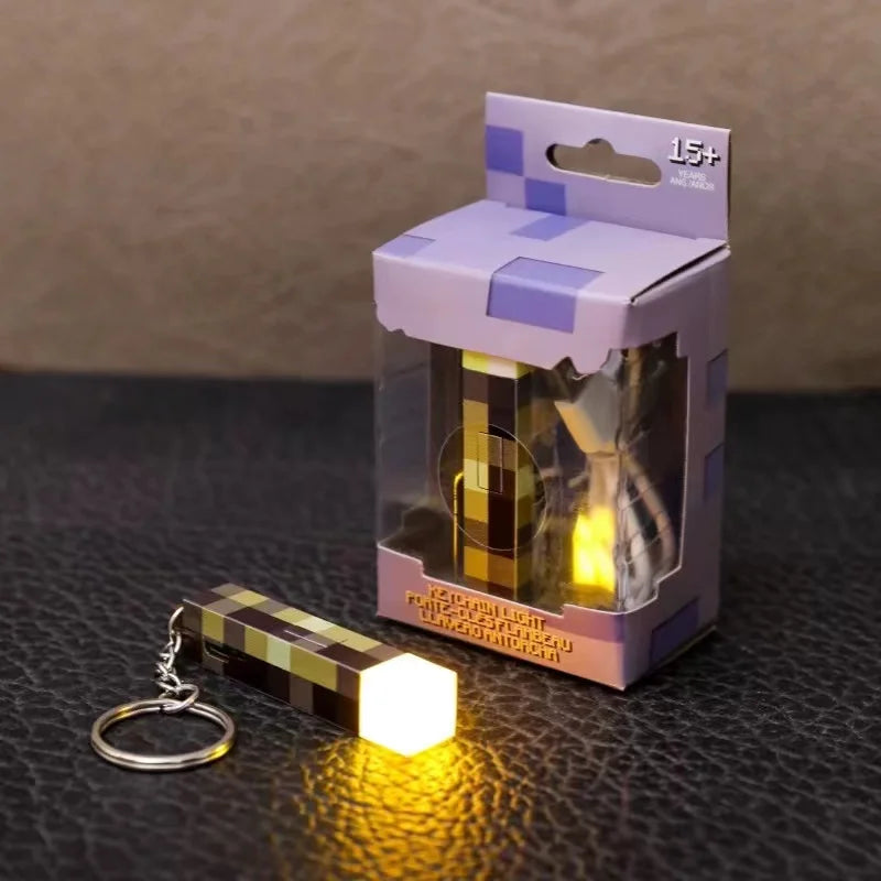 Light-up keychain with pixelated design next to its packaging on a dark surface.