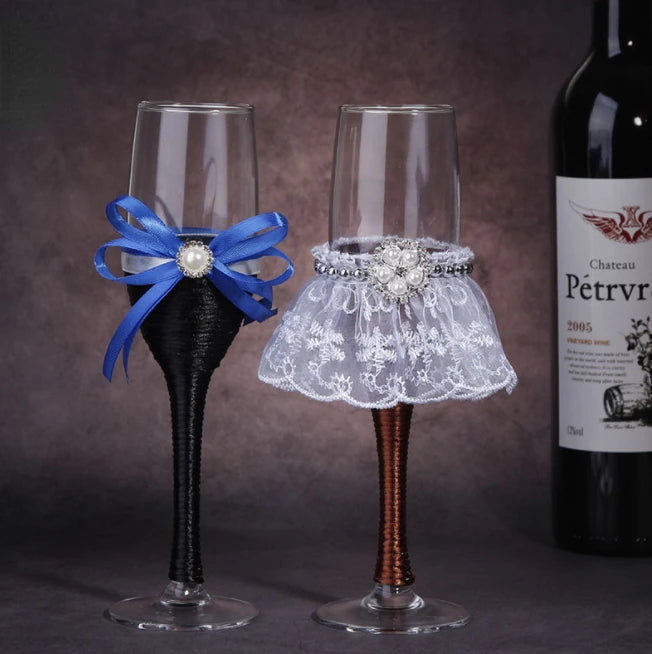Two decorative wine glasses with a blue bow and lace skirt, next to a bottle of Chateau Petrv.