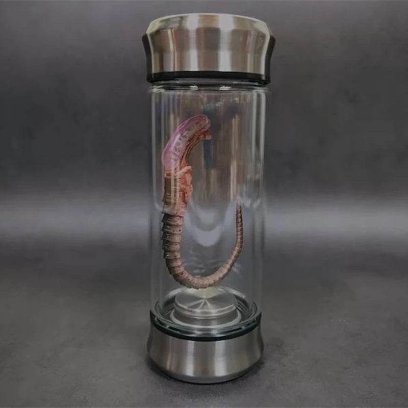 Glass bottle with a metallic cap and base on a gray background
