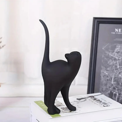 Black cat figurine on a surface with a blurred background