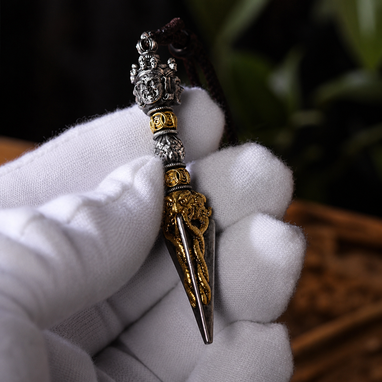 Decorative dagger held by a gloved hand with a blurred background